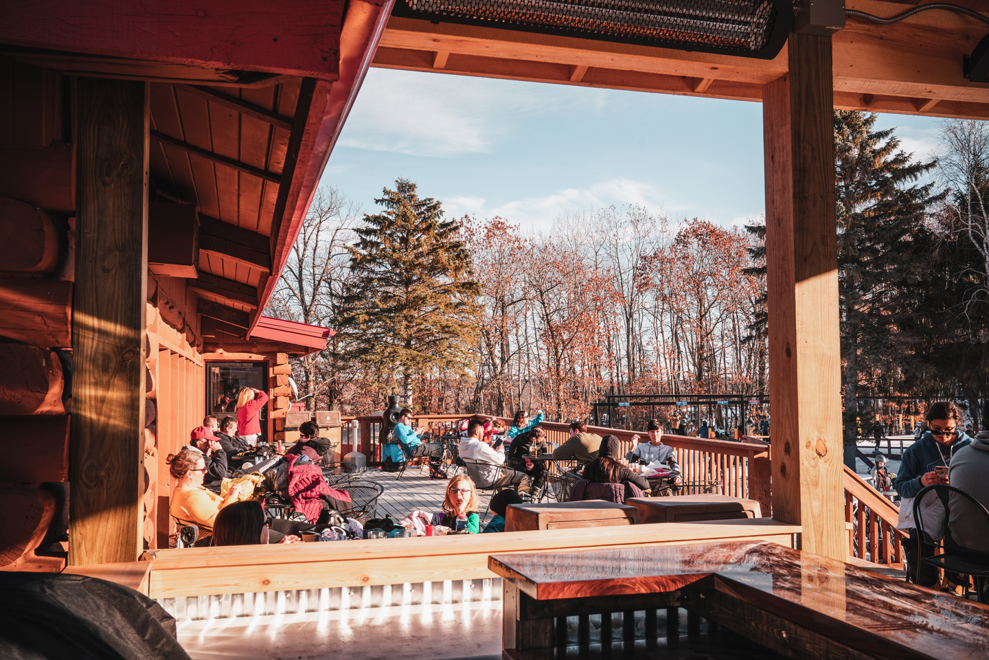 patio with people enjoying refreshments and mountain scenery
