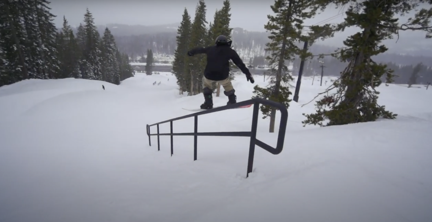 snowboarder going down rail