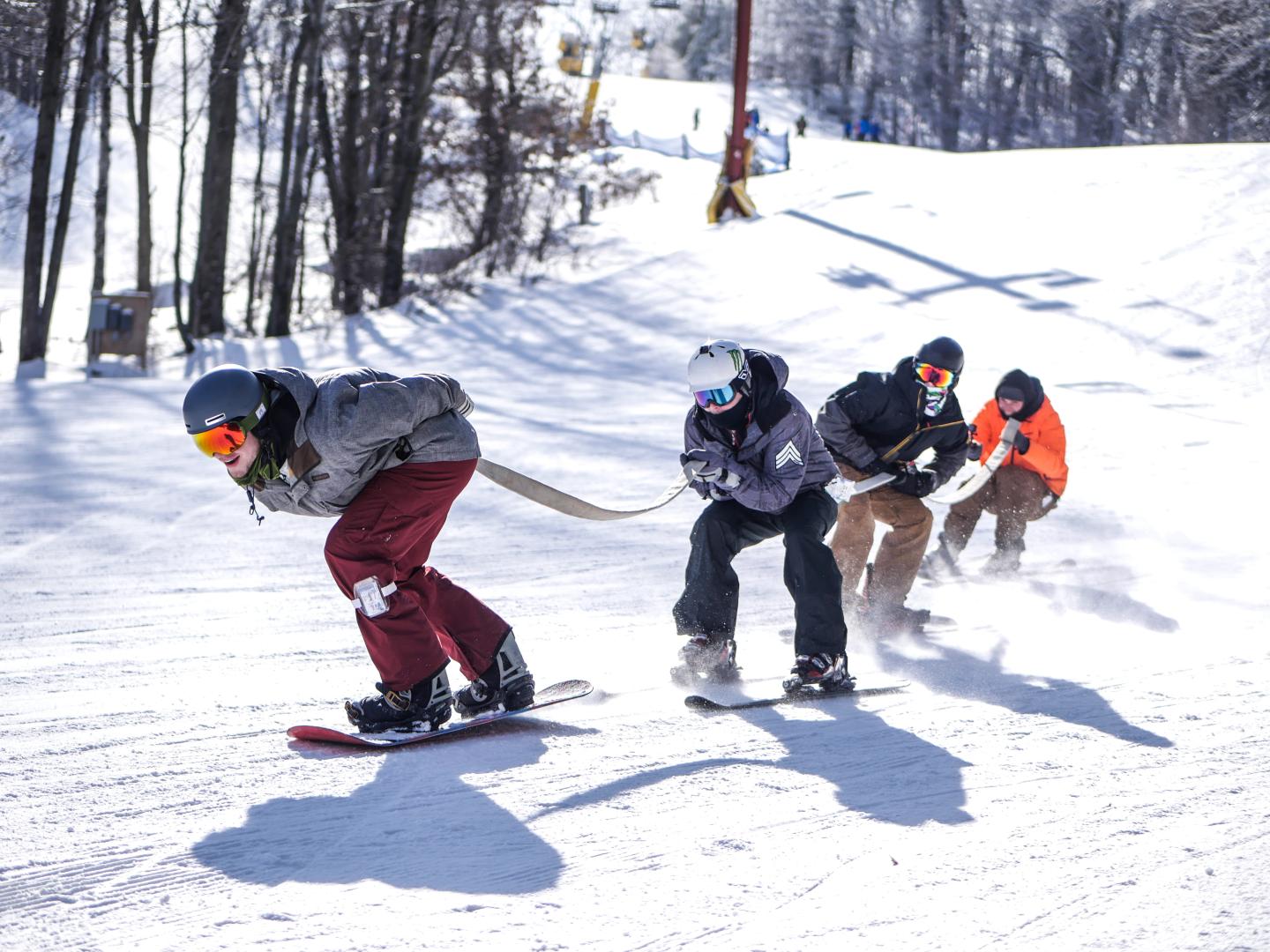 skiers trailing behind each other using rope