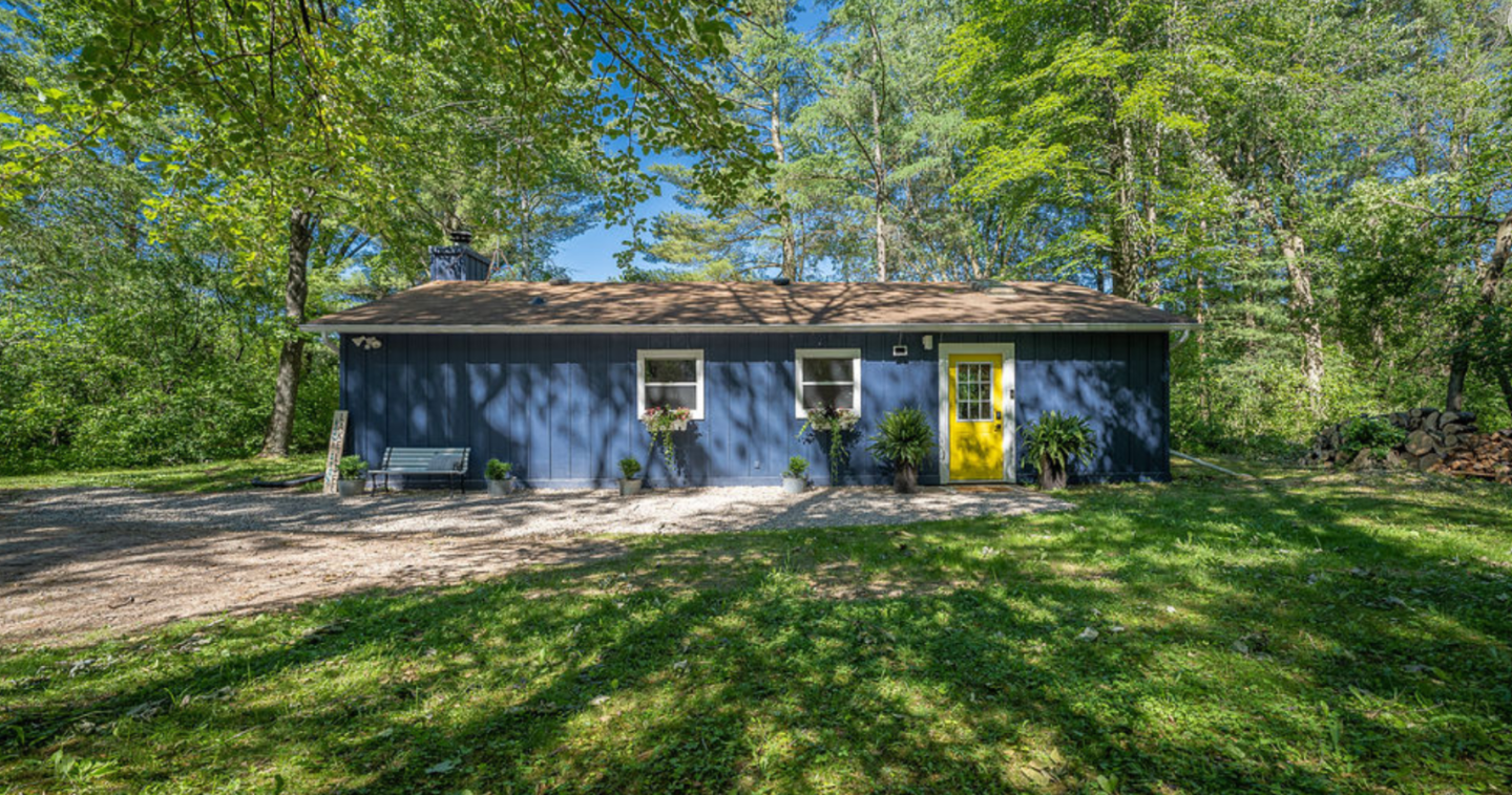 blue bungalow, placed amongst tall green trees