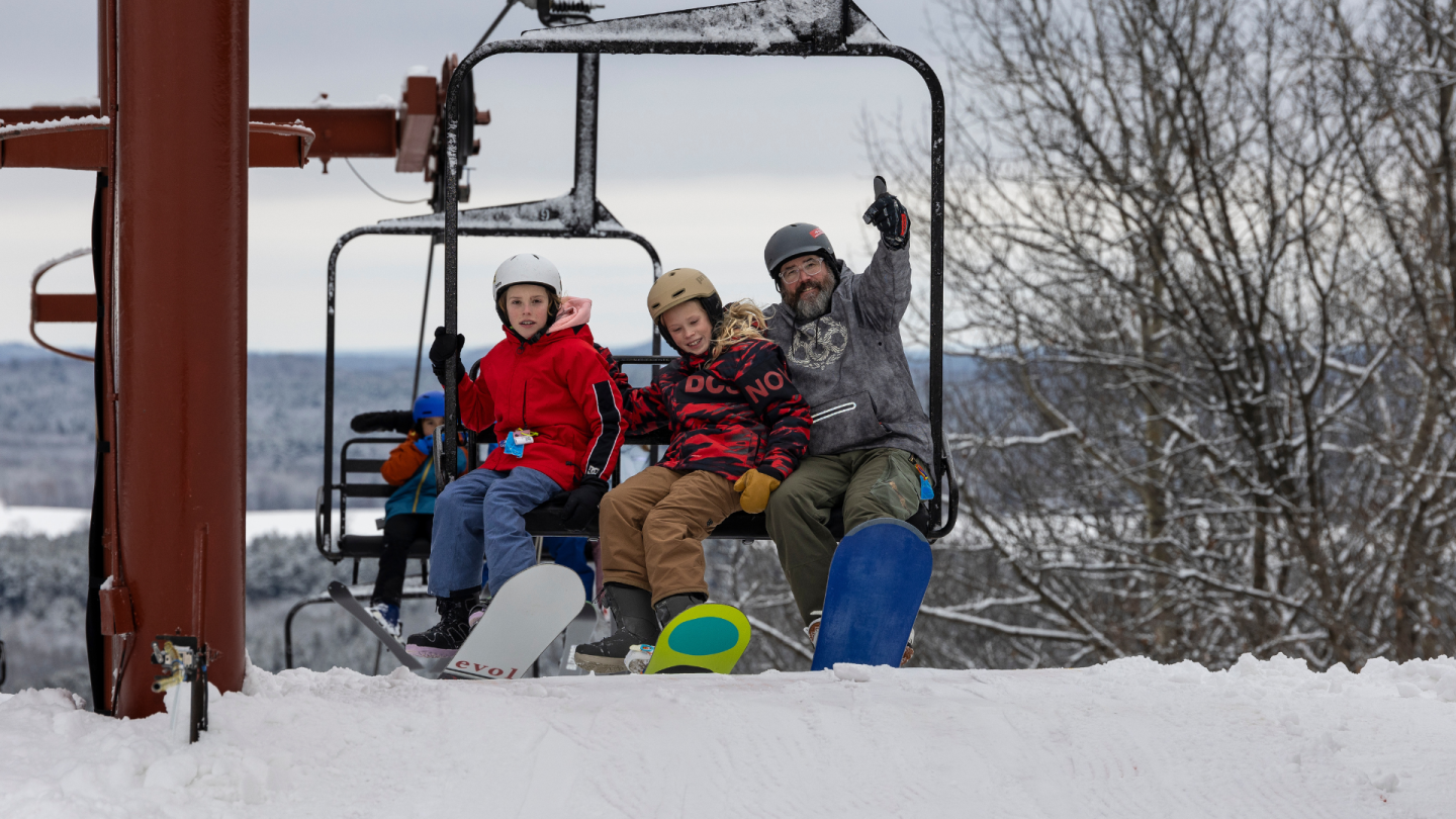 three people about to come off chair lift 