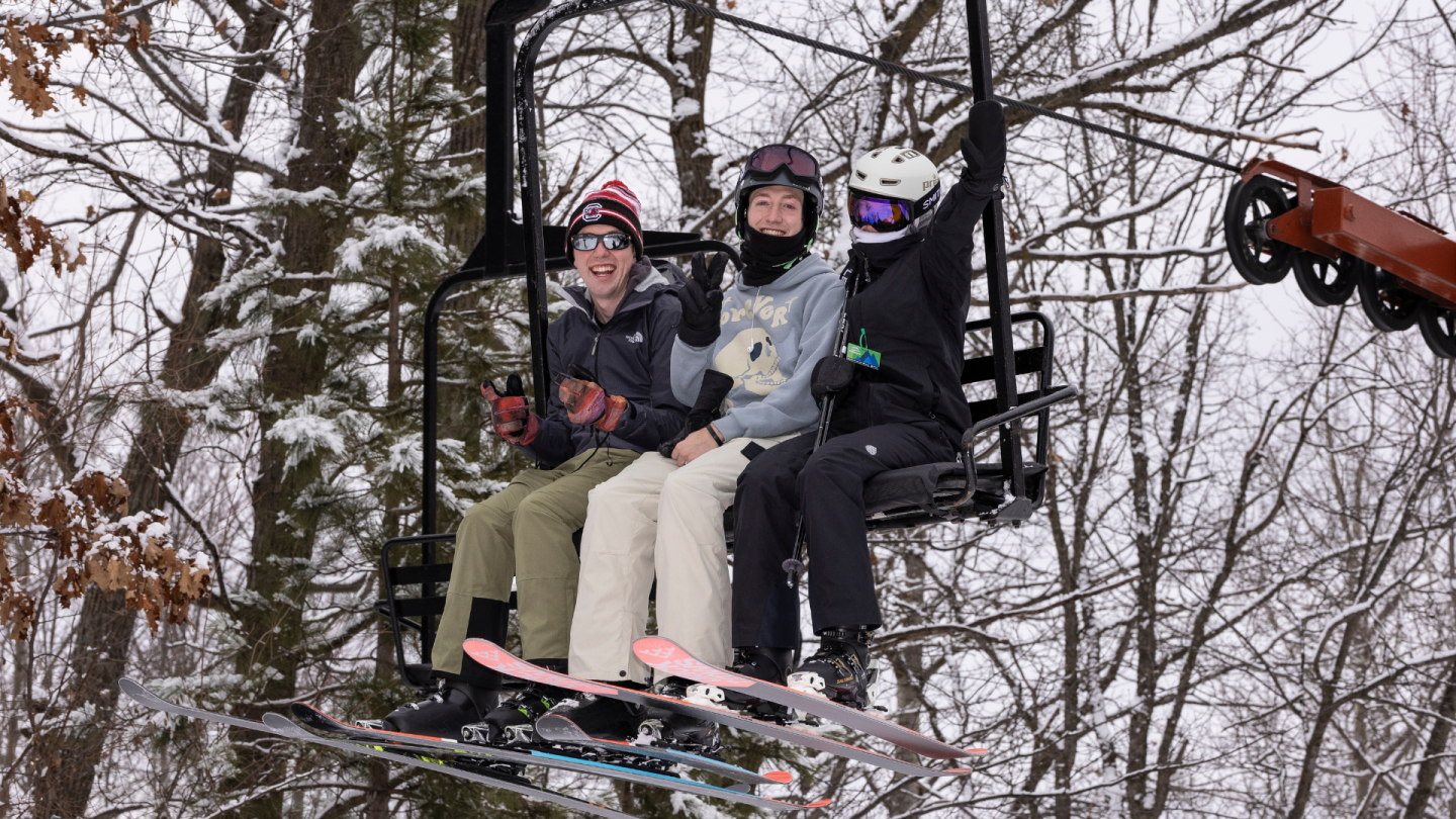 three skiers on chairlift